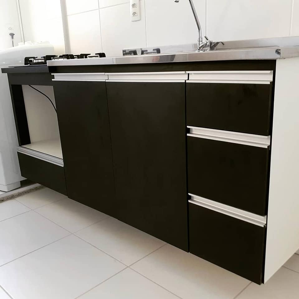 Para acertar na cor dos móveis planejados, leve em consideração a tonalidade do piso. Esse gabinete preto cria um contraste interessante com o piso claro.