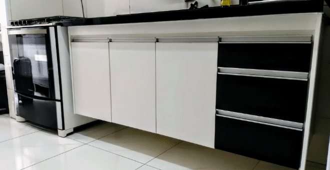 Gabinete de cozinha com três portas e três gavetas. Móvel branco com gavetas pretas. Puxadores de alumínio. Produzido em MDF