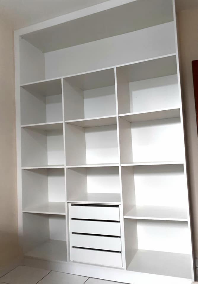 Closet planejado. Móvel branco com grandes compartimentos e quatro gavetas. 100% MDF